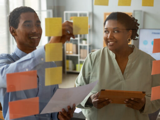 Business consultants in Ghana helping SMEs improve profitability. A Ghanaian business consultant reviewing financial performance, operating costs, and growth plans with an SME owner.